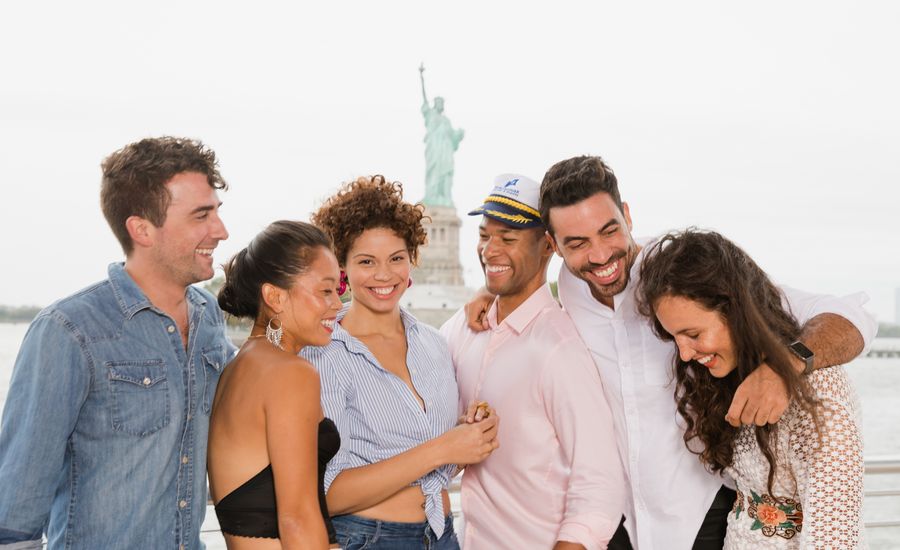 group on boat in nyc with statue in background