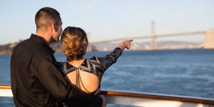 Couple avec une femme pointant du doigt le Golden Gate Bridge.
