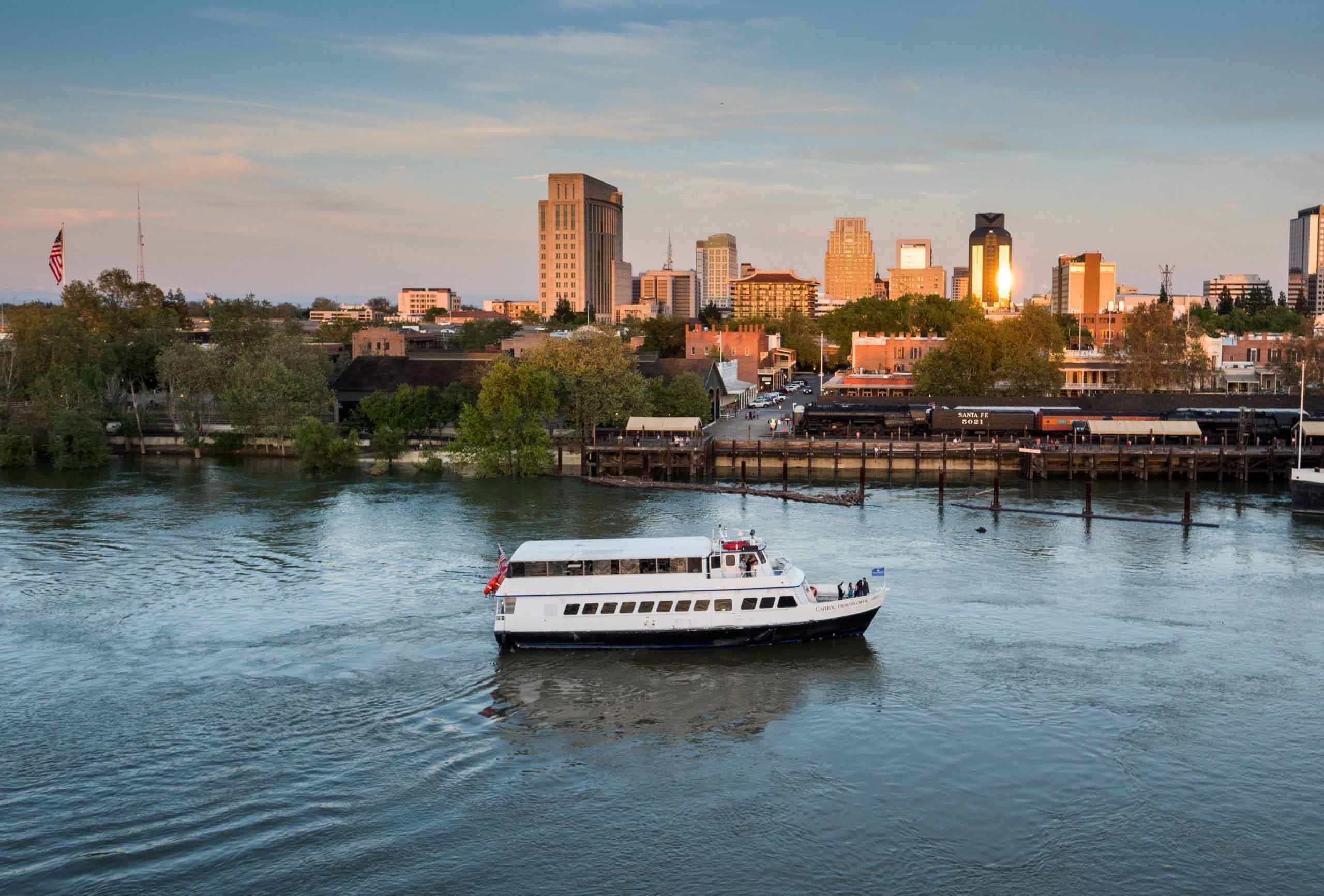 Boat on the water with Sacramento skyline in the background.