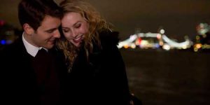 Couple hugging city lights in background