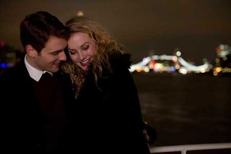 Couple hugging city lights in background