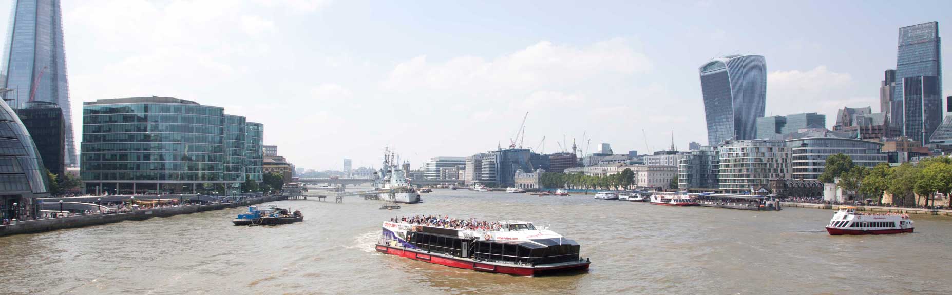 Two City Cruise boats on River Thames city on either side