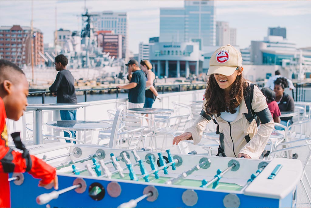 Kids playing foosball on a boat.