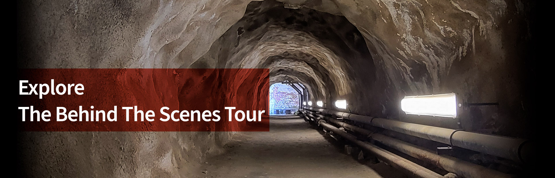 アルカトラズ島の地下にあるトンネルの画像と、画像の上に「Explorer the behind the scenes tour」と書かれたテキストが表示されています。