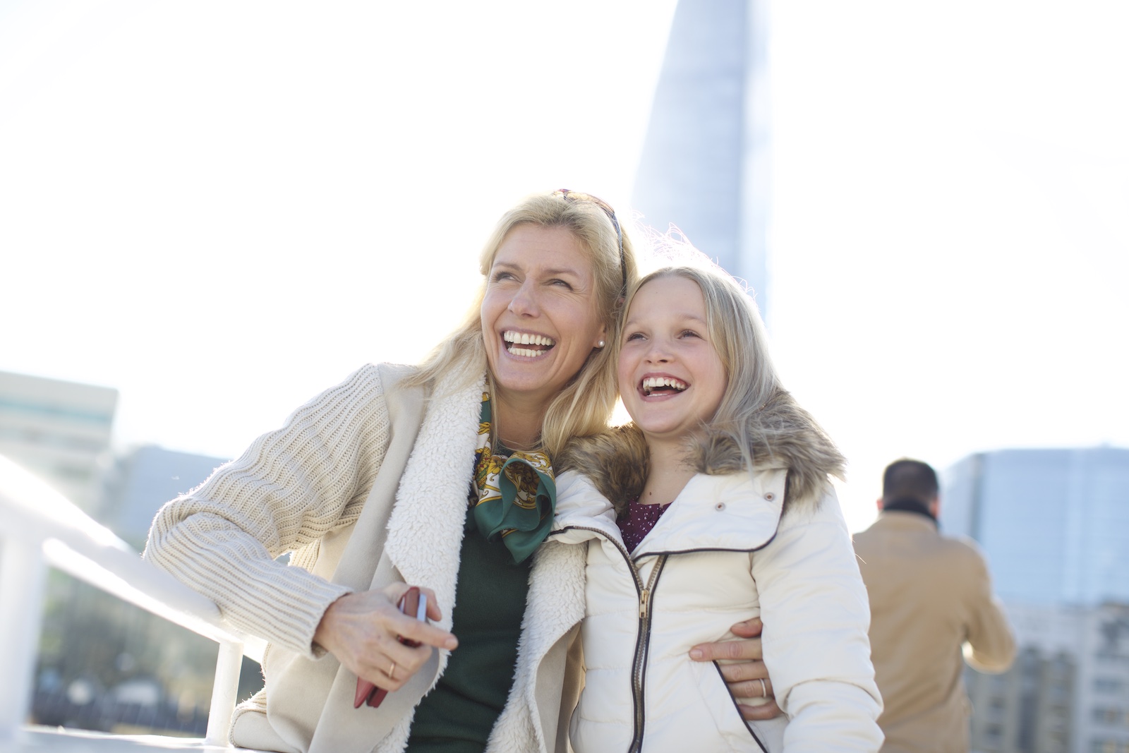 Mother and daughter on boat in London smiling.