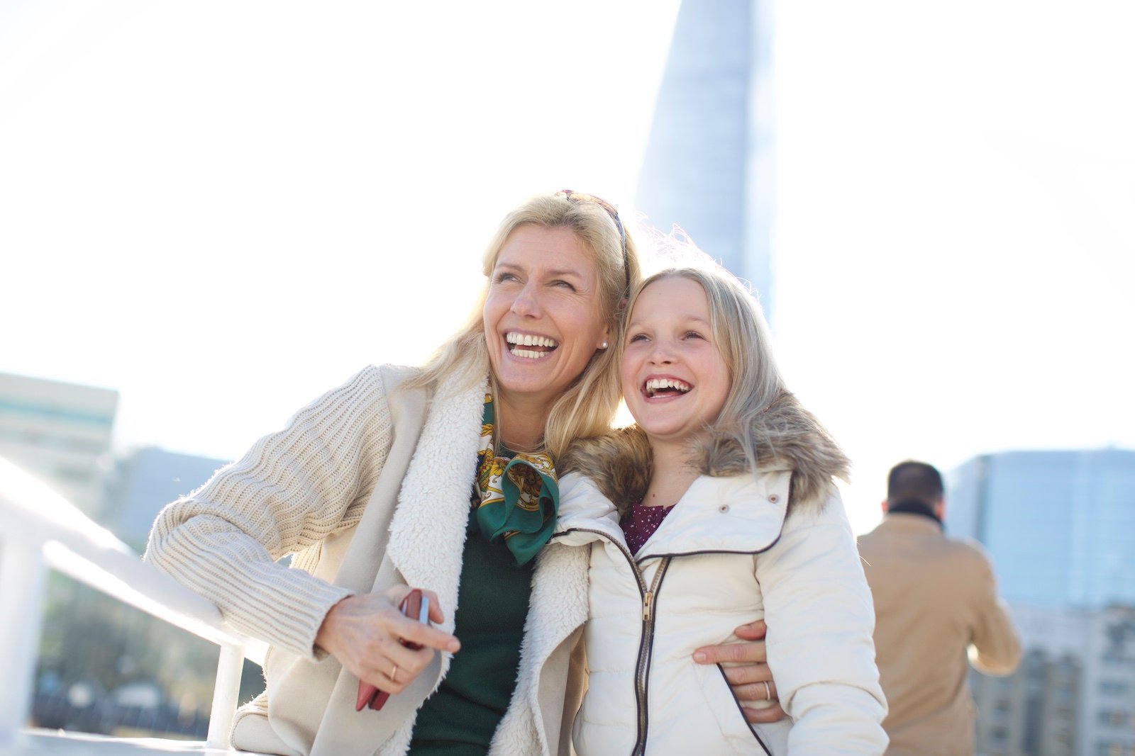 Mère et fille sur un bateau à Londres, souriantes.