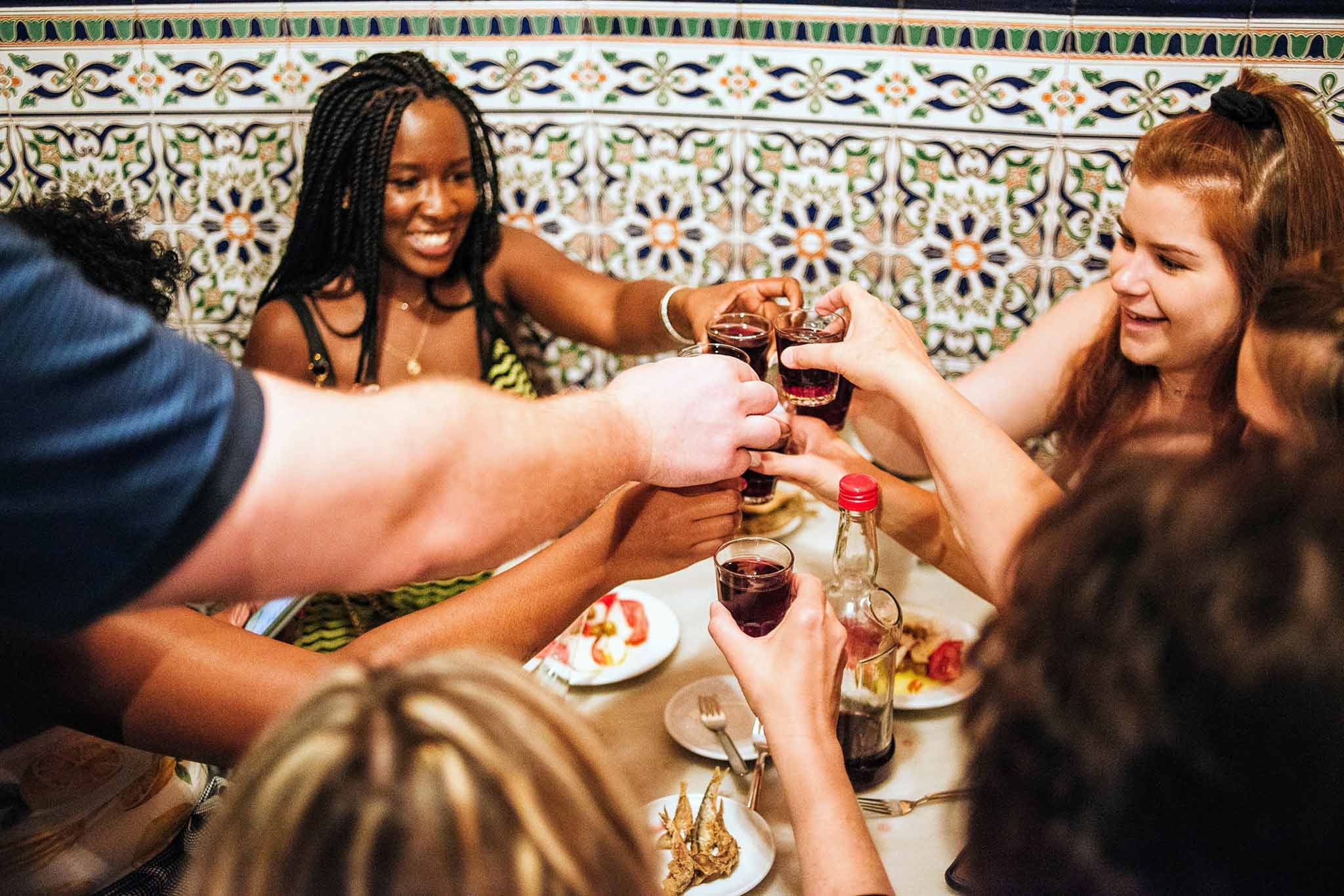 Gente animando el vino sobre una mesa con comida.