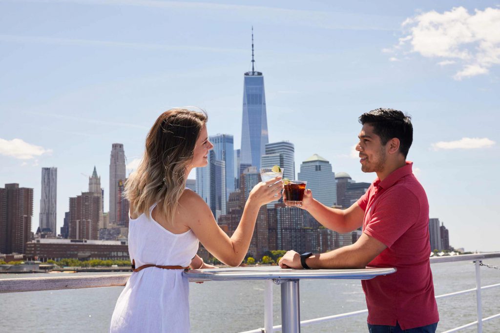 Couple cheering with One World Trade building and skyline in background.