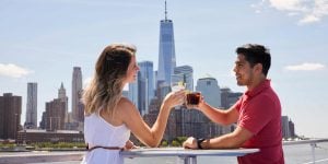 Couple cheering with One World Trade building and skyline in background.