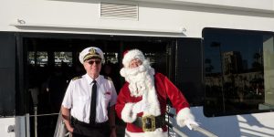 Santa and cruise ship captain standing next to boat