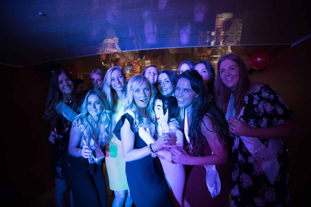Bir partide kameraya poz veren bir grup kadın.