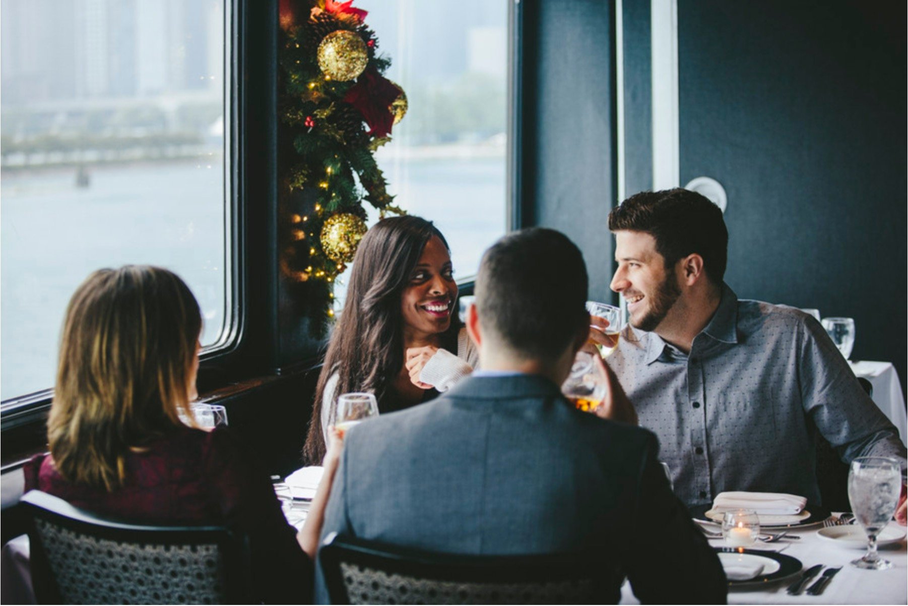 People at table with holiday garland in background.