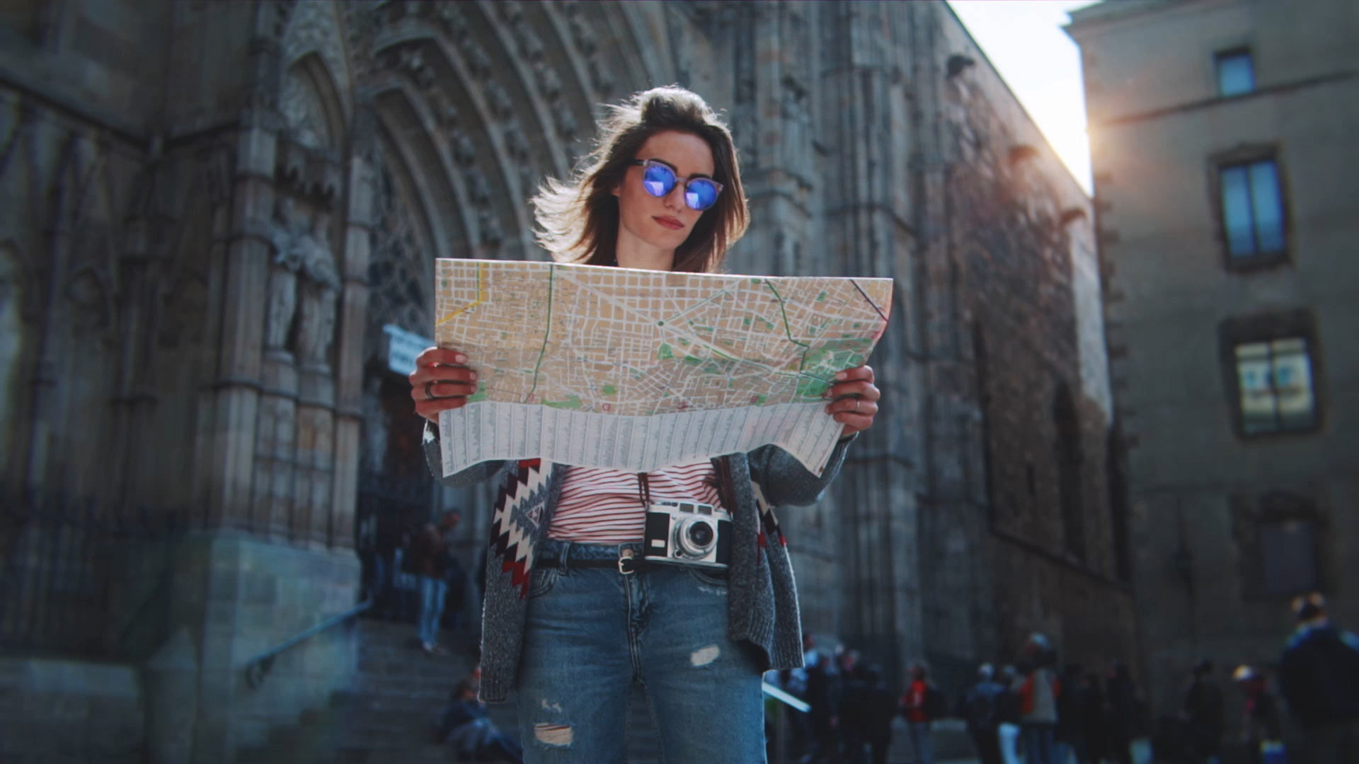 Turista en Barcelona mirando el mapa con la Catedral de Barcelona al fondo.