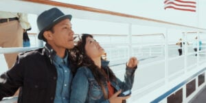 Couple on ship in San Francisco with American flag in background