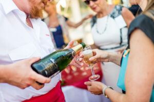 Champagne wordt geschonken in een glas dat wordt vastgehouden