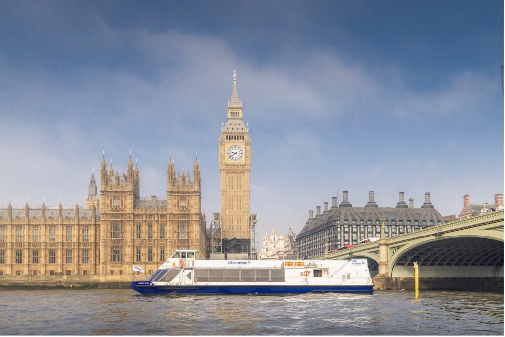 Barco de crucero por la ciudad frente al Big Ben en el río Támesis de Londres