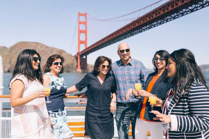 san francisco group standing in front of san francisco bridge on boat