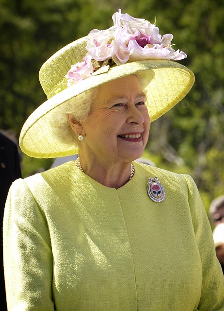 Dronning Elizabeth i gult med gul hat.