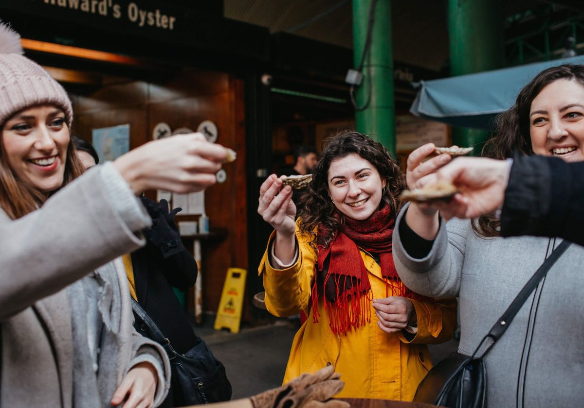 People holding up oysters before eating.