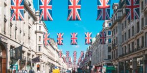 Rua em Inglaterra com bandeiras do Union Jack drapeadas entre edifícios.