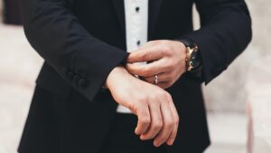 Man in suit adjusting his jacket cuff.