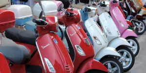 Coloridas scooters Vespa alineadas en una fila.