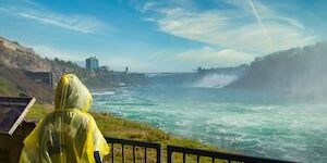 Person in yellow ponchos viewing Niagara Falls from afar.
