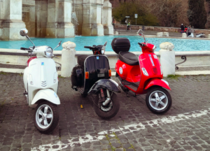 Pikipiki tatu za Vespa zilijipanga mbele ya chemchemi huko Roma Italia