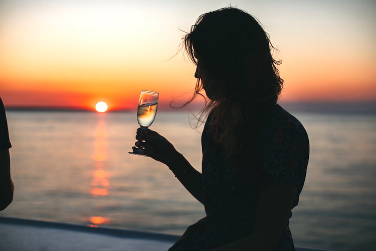 Drinking wine with sunset in background