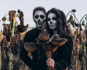 Pessoas vestidas como esqueletos num campo de milho
