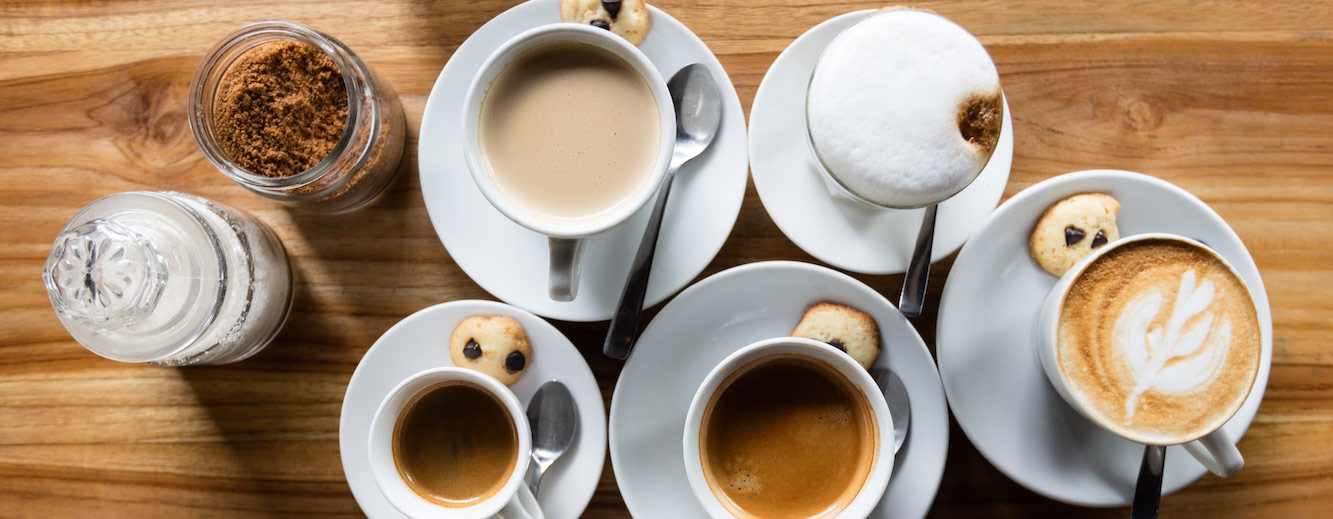 Grupo de chávenas de café em cima da mesa visto de cima.