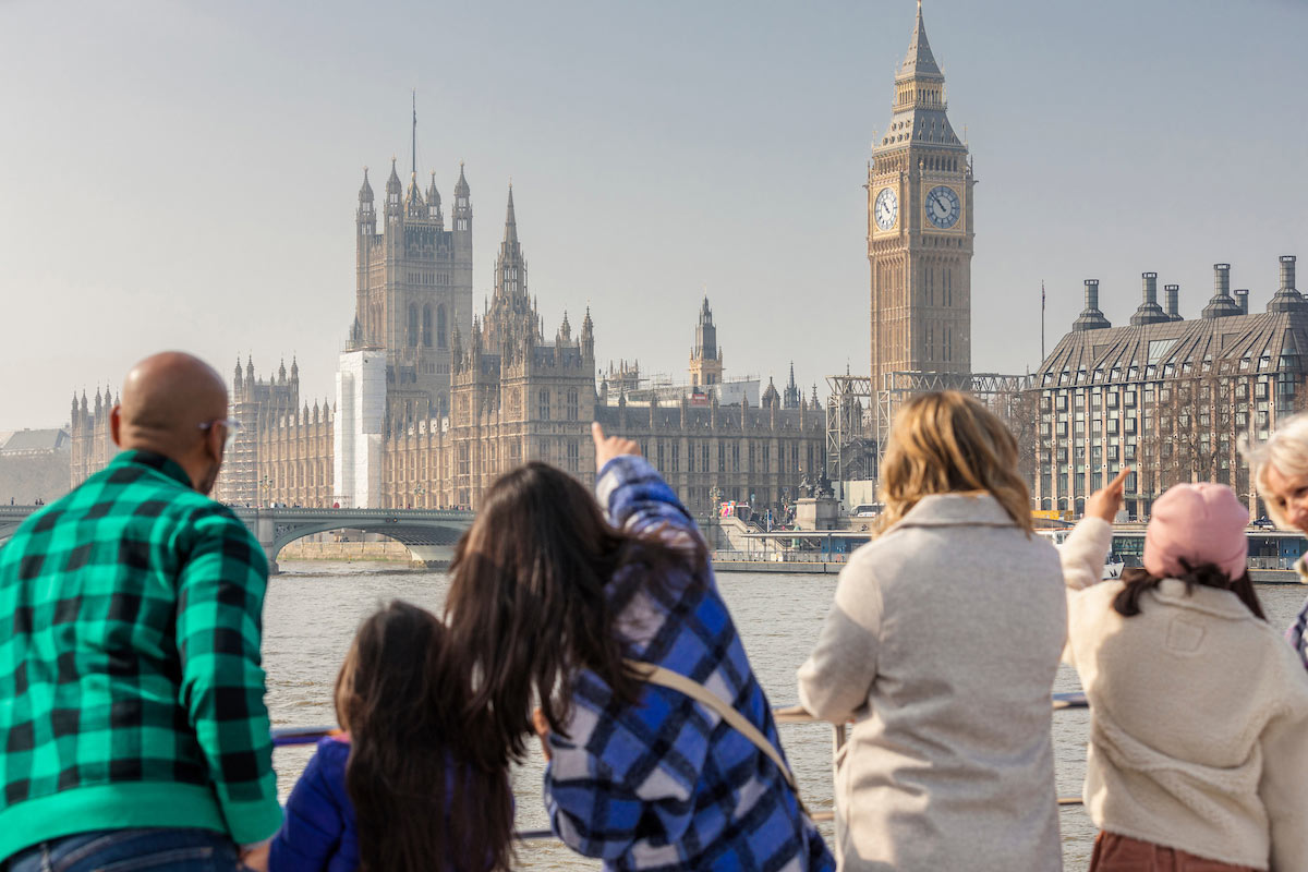イギリス・ロンドンでウェストミンスター宮殿とビッグベンを眺める人たち。