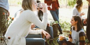 Frau trinkt Wein mit einer Gruppe von Freunden