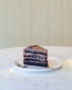 Um pedaço de bolo de chocolate numa mesa de mármore branco