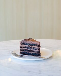 Een stuk chocoladetaart op een witte marmeren tafel