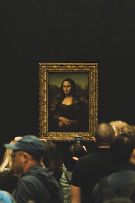 La Mona Lisa al fondo mientras la gente mira.