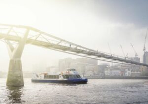 A City Cruises boat going under the Millennium Bridge London England