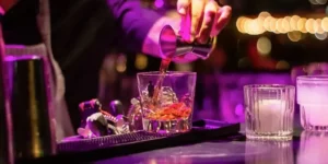 Drink being mixed on top of a bar