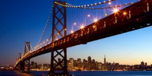 San Francisco - Oakland Bay Bridge om natten oplyst
