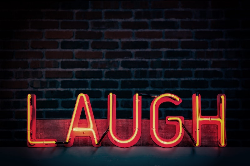 A neon sign reading Laugh