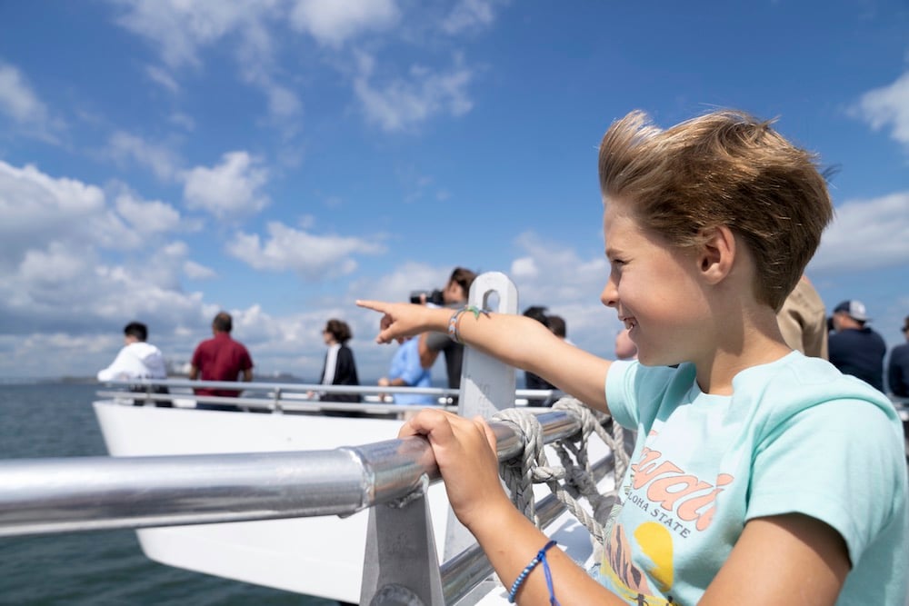 Seorang kanak-kanak menunjuk ke arah air dari bot.