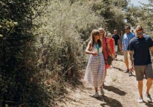Rejseleder går på en grusvej med en rejsegruppe