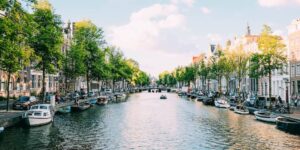 Canal de Amesterdão forrado com barcos e árvores