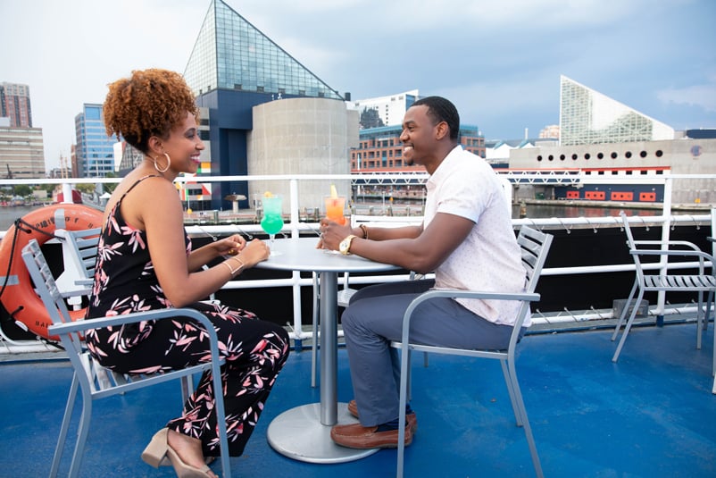 personas sentadas a la mesa a bordo de un crucero con bebidas