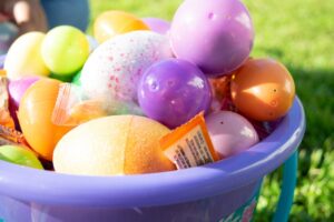 Panier de Pâques rempli d'œufs en plastique et de bonbons