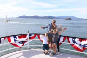 Keluarga di dek bot San Francisco Bay di latar belakang
