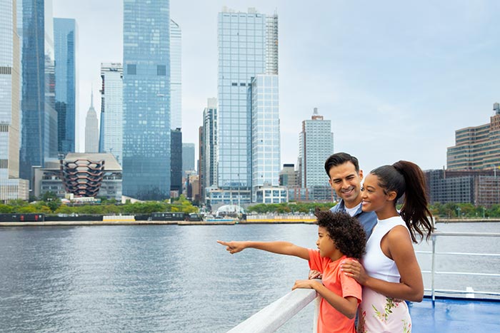 family looking at new york skyline from cruise yacht
