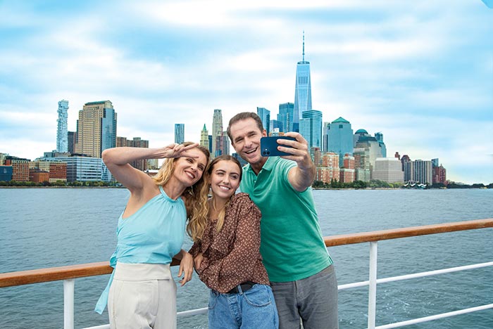 family taking selfie cruising by new york skyline
