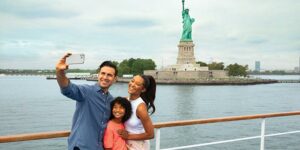 familie neemt selfie terwijl ze langs het vrijheidsbeeld cruisen