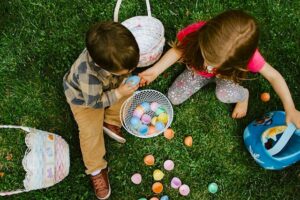 Dos niños con cestas de Pascua en el césped